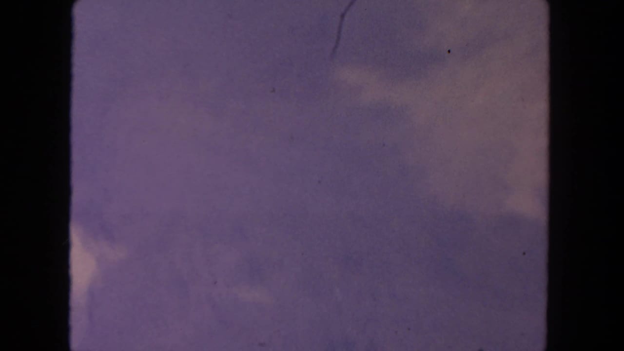 Soft purple sky and faint clouds bordered by dark 8mm film edges.