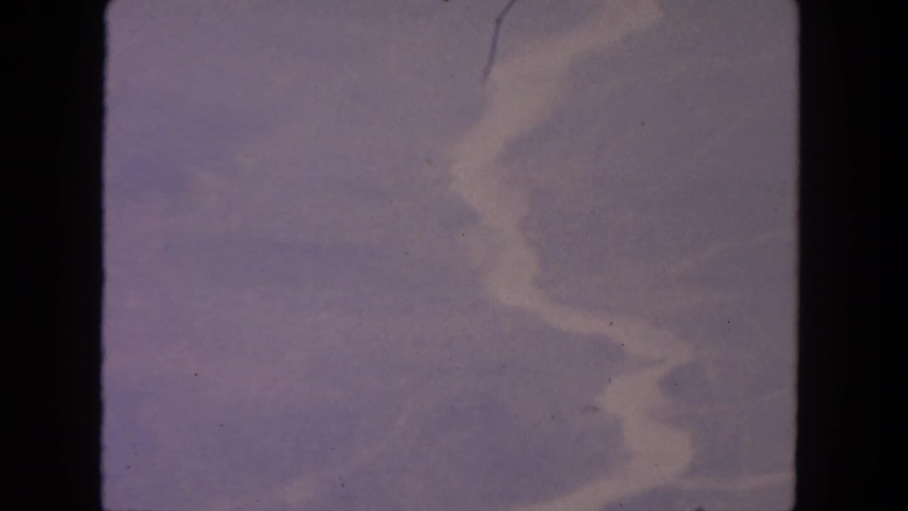 Soft purple clouds and pale sky within rounded 8mm film edges.
