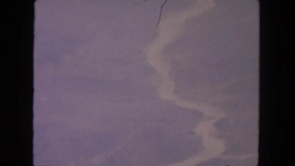 1962 8mm home-movie frame from San Diego metadata showing lavender sky and faint cloud texture with film wear.