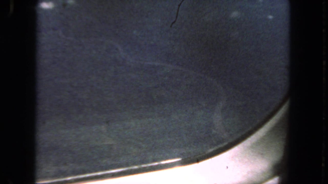 Dim blue-gray sky framed by the curved lower edge of an airplane window.