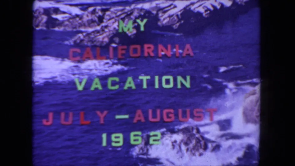 1960s 8mm title card for a California vacation, with block lettering and a blue rocky shoreline background.