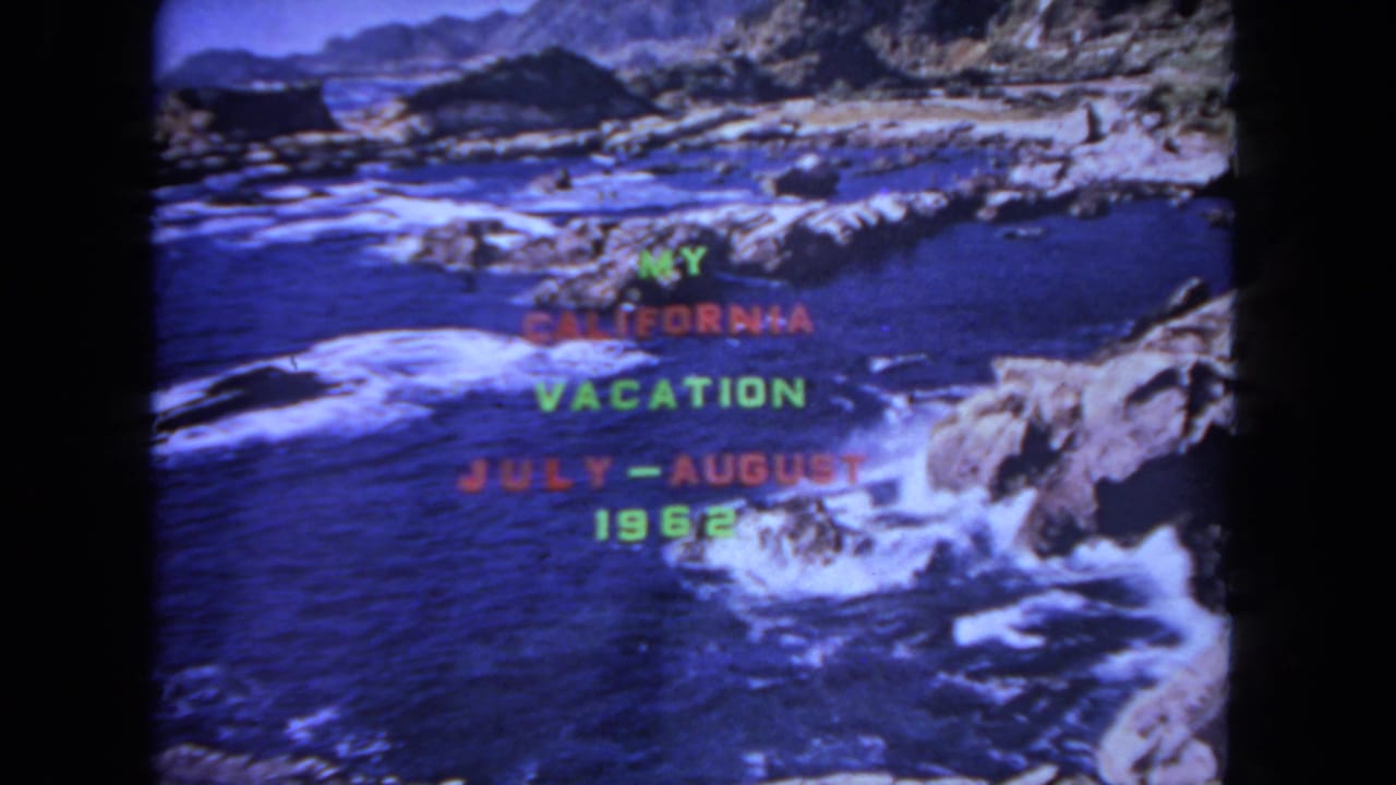 Colored vacation title text over waves breaking along a rocky California shoreline.