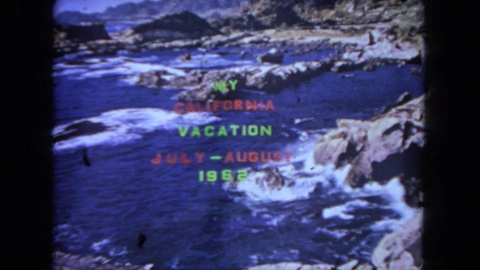 The 1962 California vacation title remains centered over a rocky shoreline with bright surf, blue water, and visible 8mm film borders.
