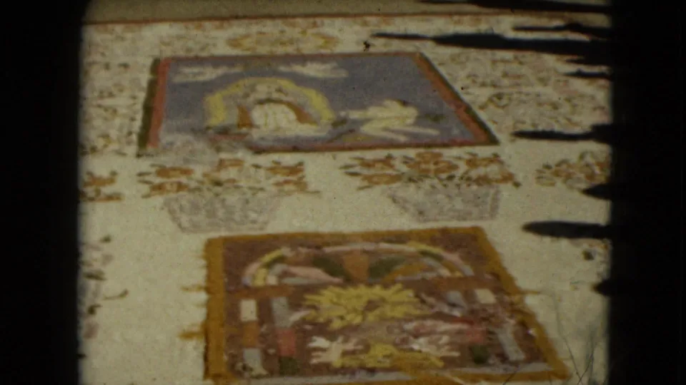 Close 1962 home-movie view of Mexican religious textile or folk-art panels, softened by grain and slight blur.