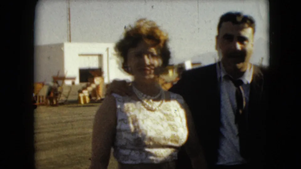 The couple smiles and poses together in 1962 Mexico City, with the man's arm around the woman in a white dress.