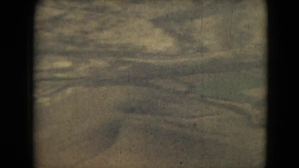 1962 8mm frame from Mexico metadata with a broad snowy mountain surface seen from above and softened by archival film texture.