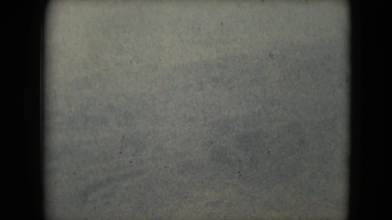 Soft, hazy mountain ridge and open terrain within rounded film borders.