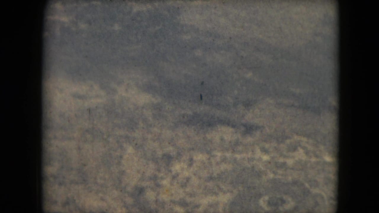 Soft aerial view of muted terrain seen through an 8mm frame edge.