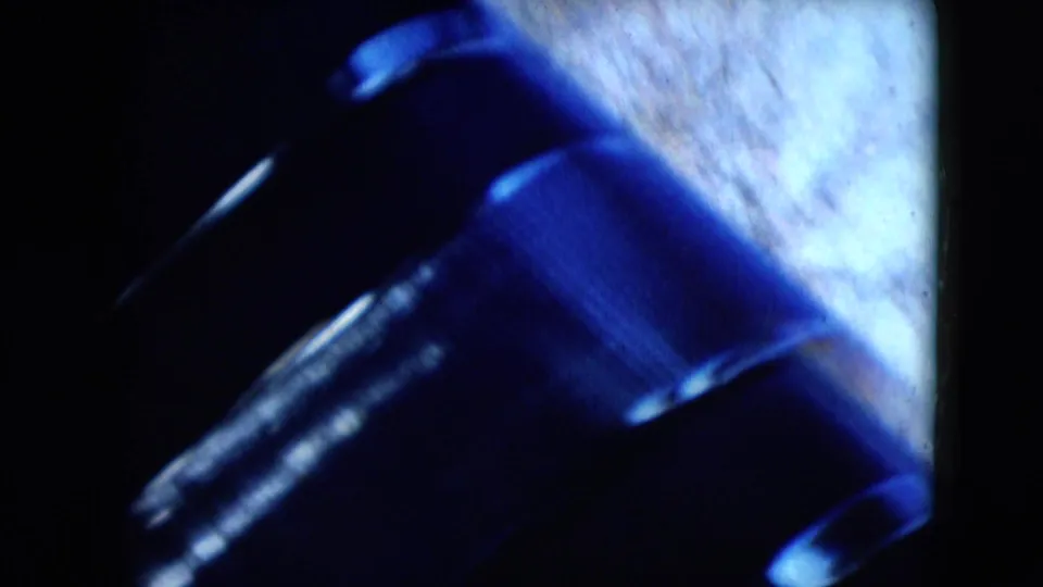 A close view appears to show a black leather-like car interior surface, likely a seat or dashboard area, beside a bright blurred exterior.