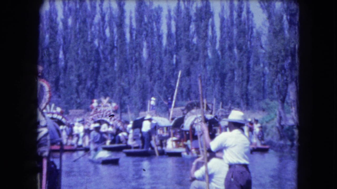 1962 Mexico City canal scene with passengers, pole boats, straw hats, trees, and a small visible sign in the distance.