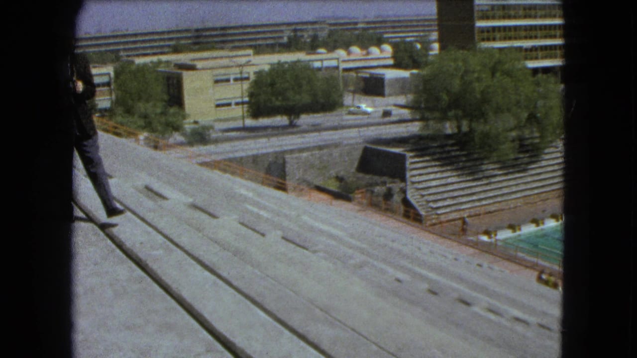 Concrete overlook above roads, trees, bleachers, and modern buildings.