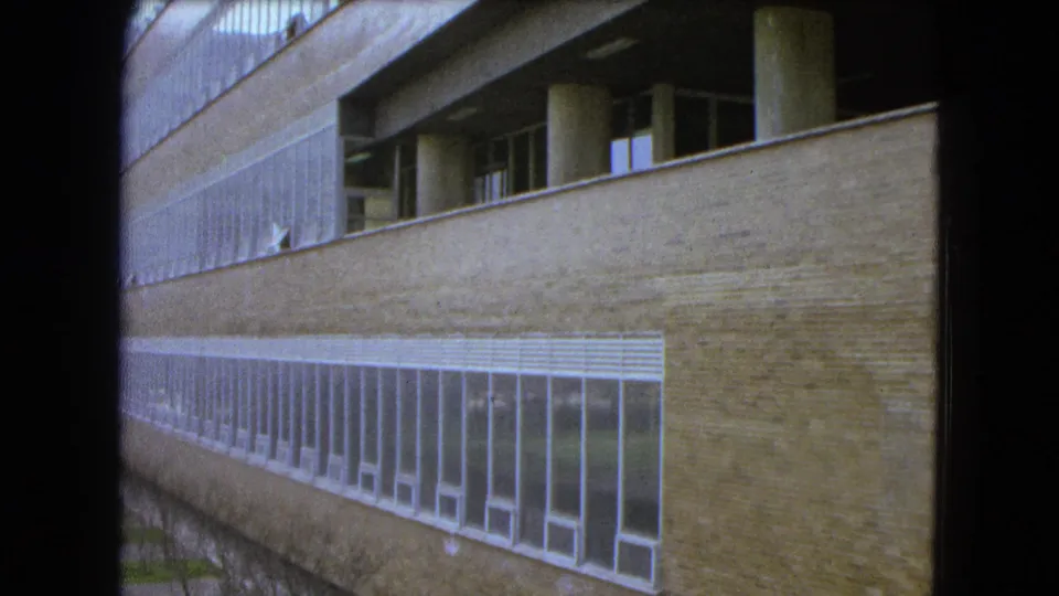 Modern school building exterior in Mexico City, showing brick walls, long window bands, and shaded upper levels.