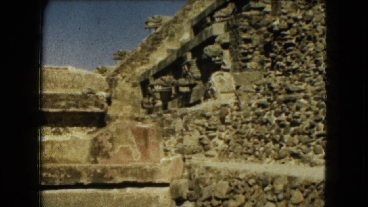 1962 Mexico City travel footage frame holding on rough stone ruins with carved elements and a stepped platform.
