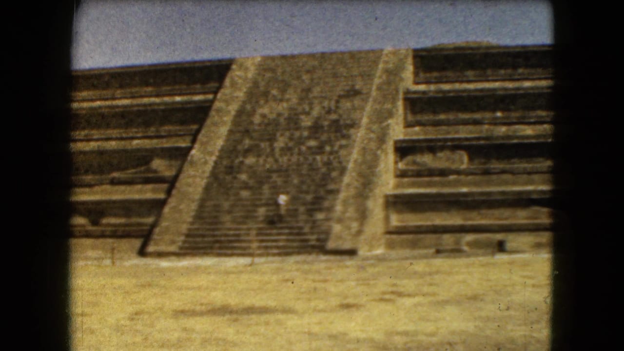 Sunlit pyramid staircase and stone terraces seen through an 8mm film frame.