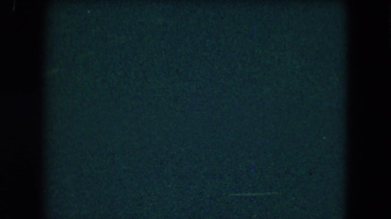 Dark blue-green film area with black borders and no clear subject visible.