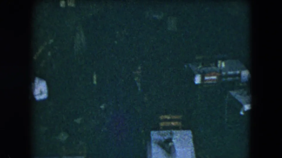 1962 Mexico City home-movie frame showing a dim restaurant interior with tables being arranged before service.
