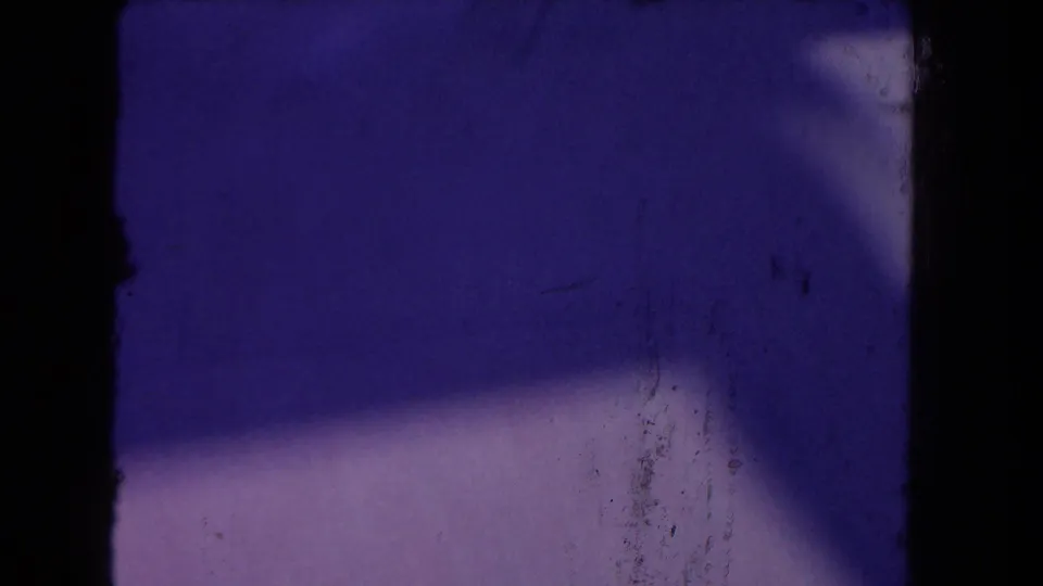 End frame shows mostly blue-purple exposed film area with shadowing, dust, and limited visible subject detail from the 8mm scan.