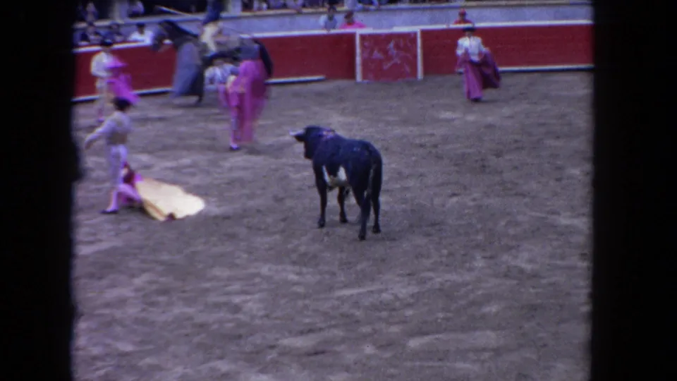 1962 Los Angeles 8mm frame with the bull facing forward and the matador near a yellow cape on the arena floor.