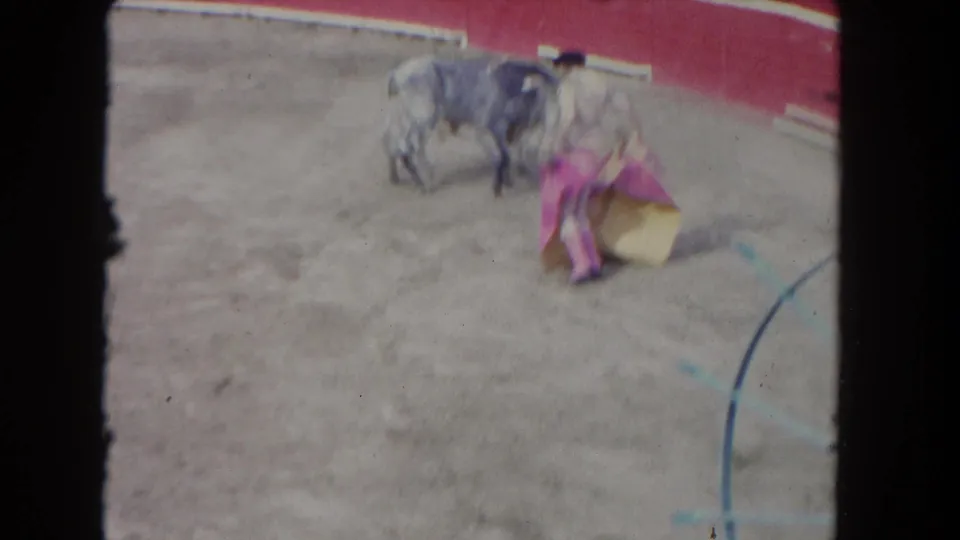 A 1962 Los Angeles bullfighting-style frame shows the bull close to the matador as the cape drops low in the ring.