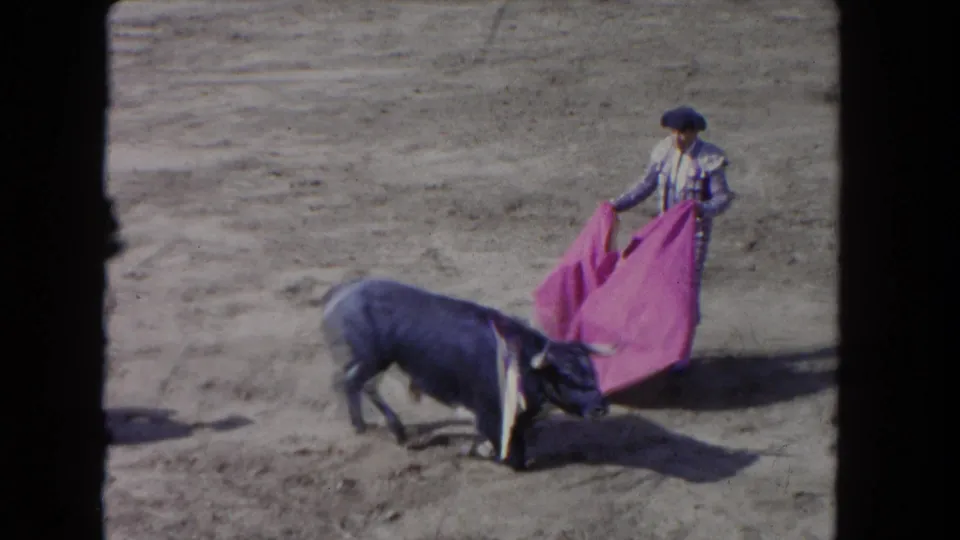 1962 Los Angeles 8mm frame with a matador holding a pink cape while the bull lowers its head close to the cloth.