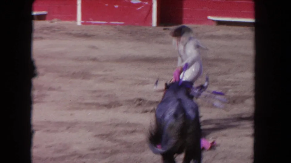 1962 Los Angeles frame with a matador near a black bull in the sandy ring, with colored banderillas visible on the animal.