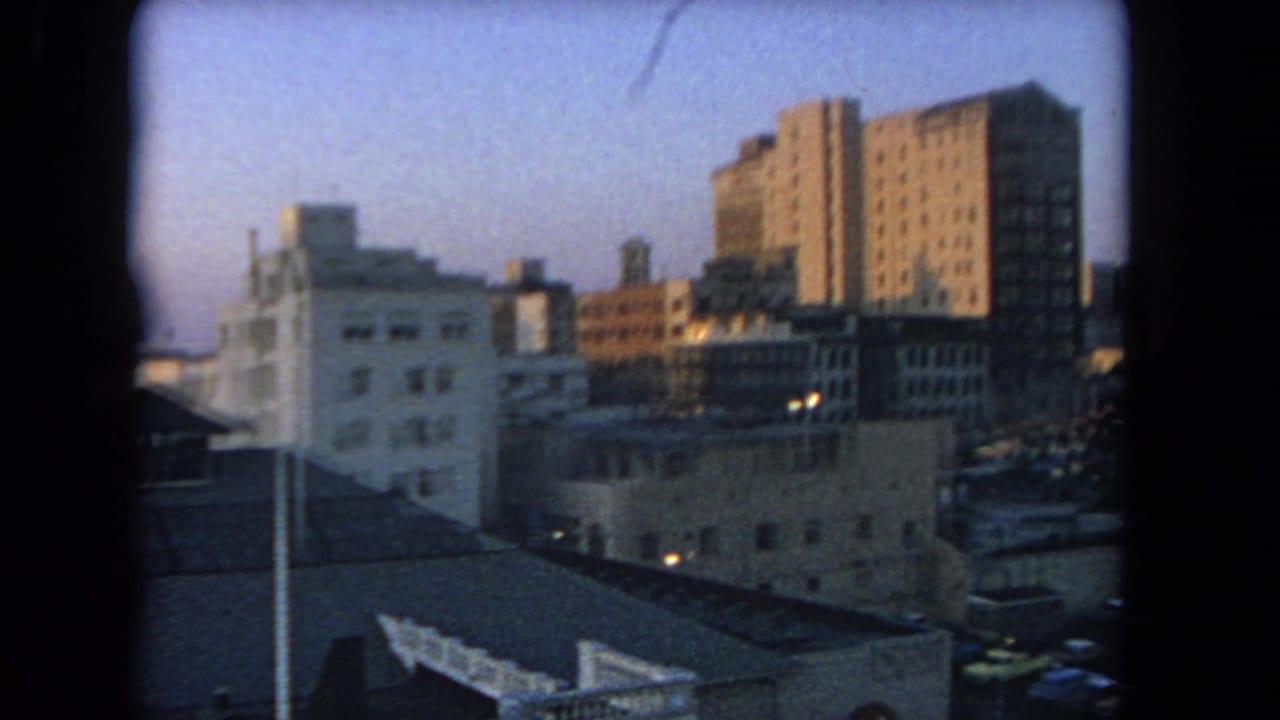 Dusk view of mid-rise buildings seen through dark 8mm film borders.