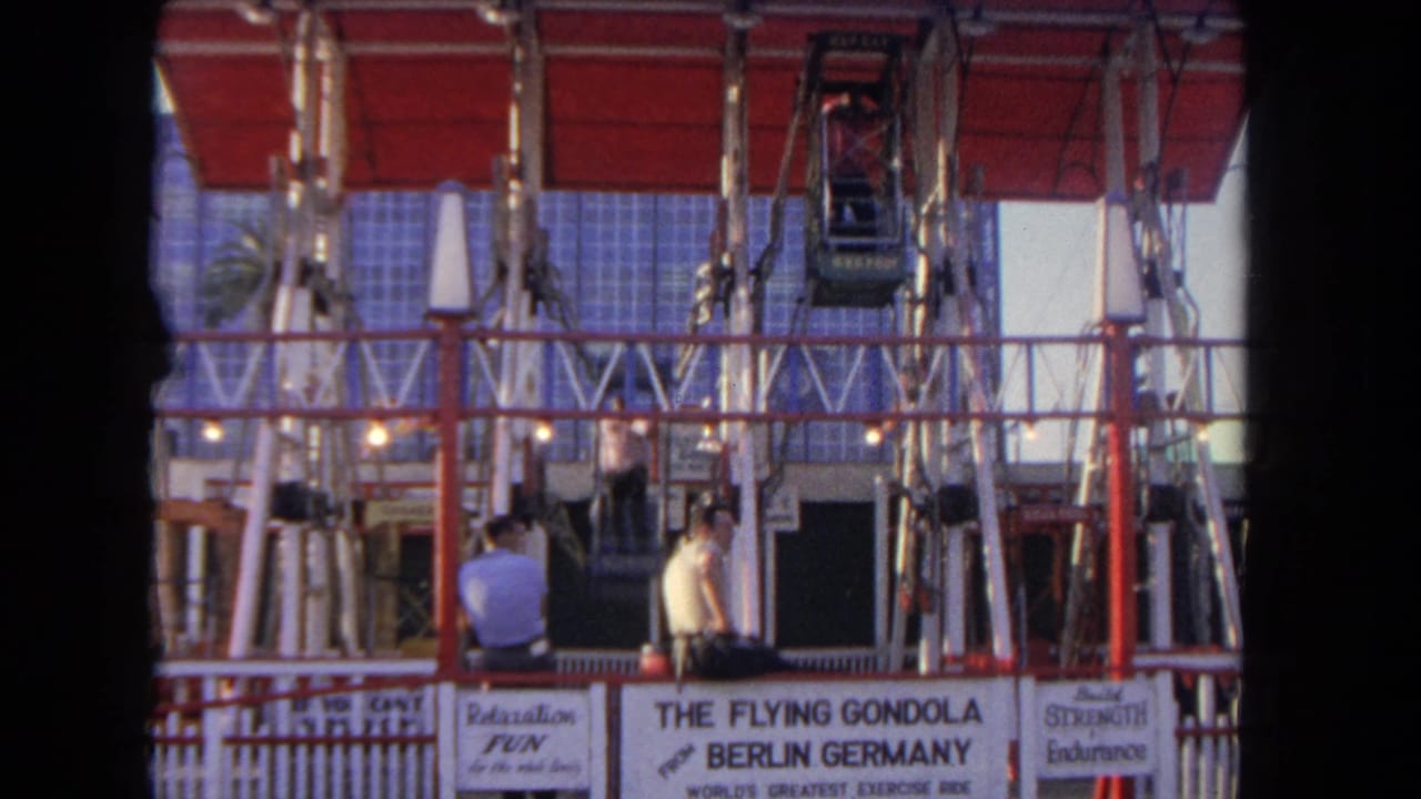 Gondola ride platform with two men below and cars suspended in the frame.