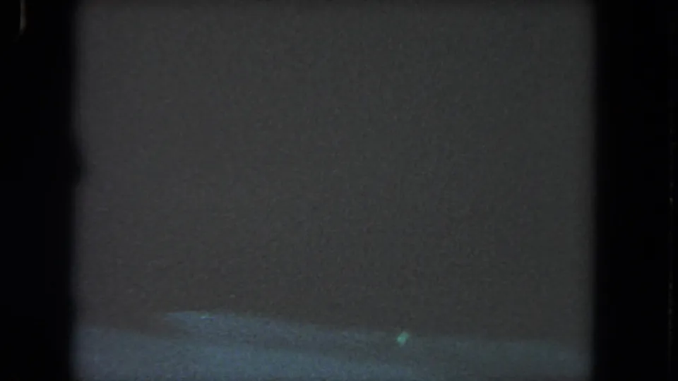 1962 8mm underwater footage near Los Angeles begins in murky blue-green water with dark film borders and faint suspended particles.