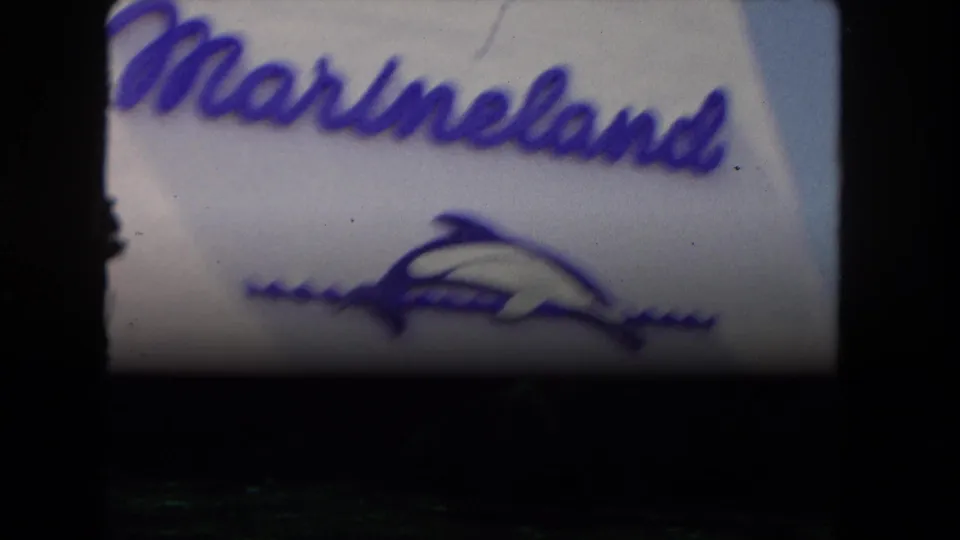 Final 1962 8mm frame of the Marineland sign, partly obscured by darkness as the shot fades or ends.