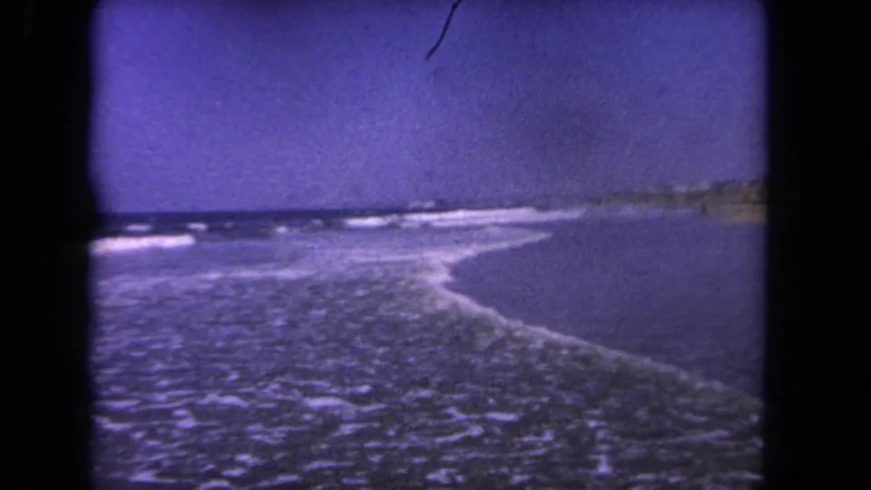 1962 Los Angeles coastal view with surf lines, open ocean, and a faint stretch of shoreline in soft 8mm color.
