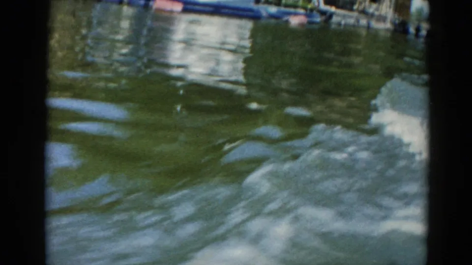 Low-angle close-up of disturbed lake water surface shot from a moving watercraft, Illinois lake, circa 1962.