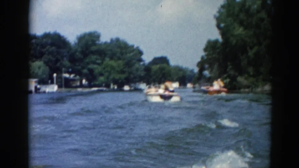 1962 Illinois waterway showing several small motorboats on open water near tree-lined banks, with possible passengers visible at distance