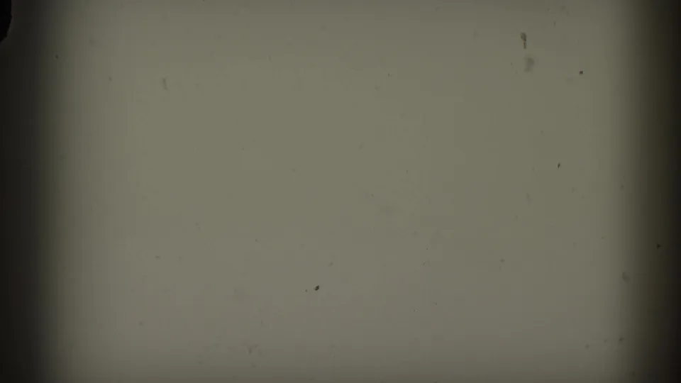 Clear or blank 8mm film frame showing emulsion grain and dust particles; likely a gap between shots or reel end.