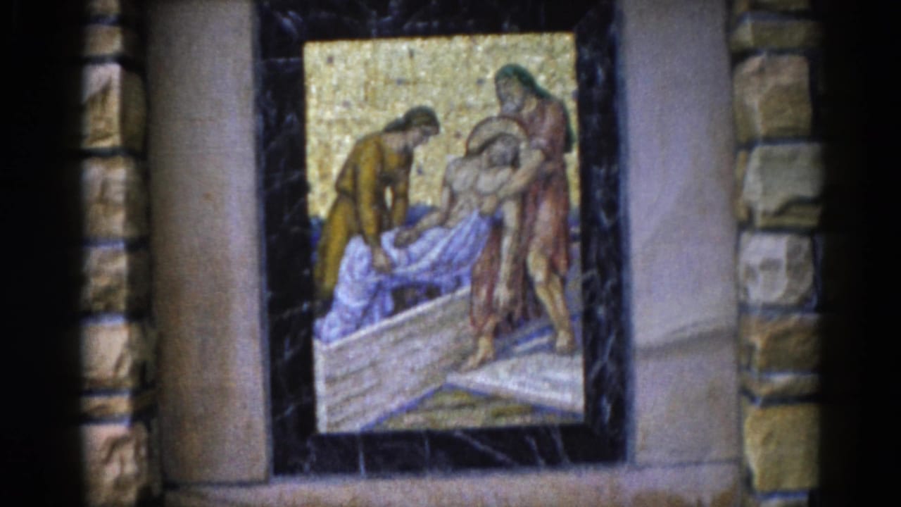 Close-up of a religious mosaic depicting robed figures in a biblical scene, set within a dark stone-framed niche with a golden tesserae background.