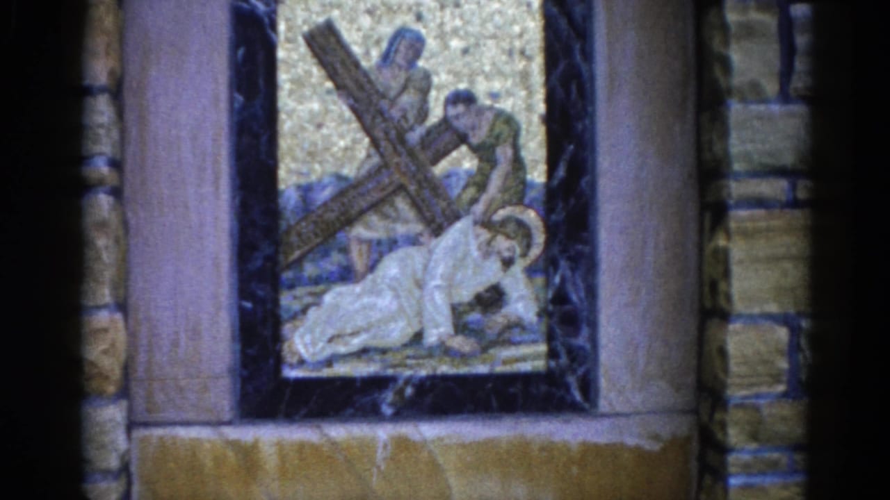 Mosaic panel showing a haloed figure beneath a wooden cross with two nearby figures, gold tessellated background, framed by dark marble columns.