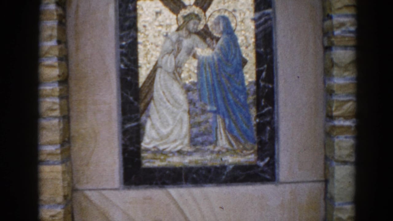 1962 Illinois church: 8mm footage of a mosaic depicting two figures — one haloed in white robes, one in blue mantle — against a gold tessera background.