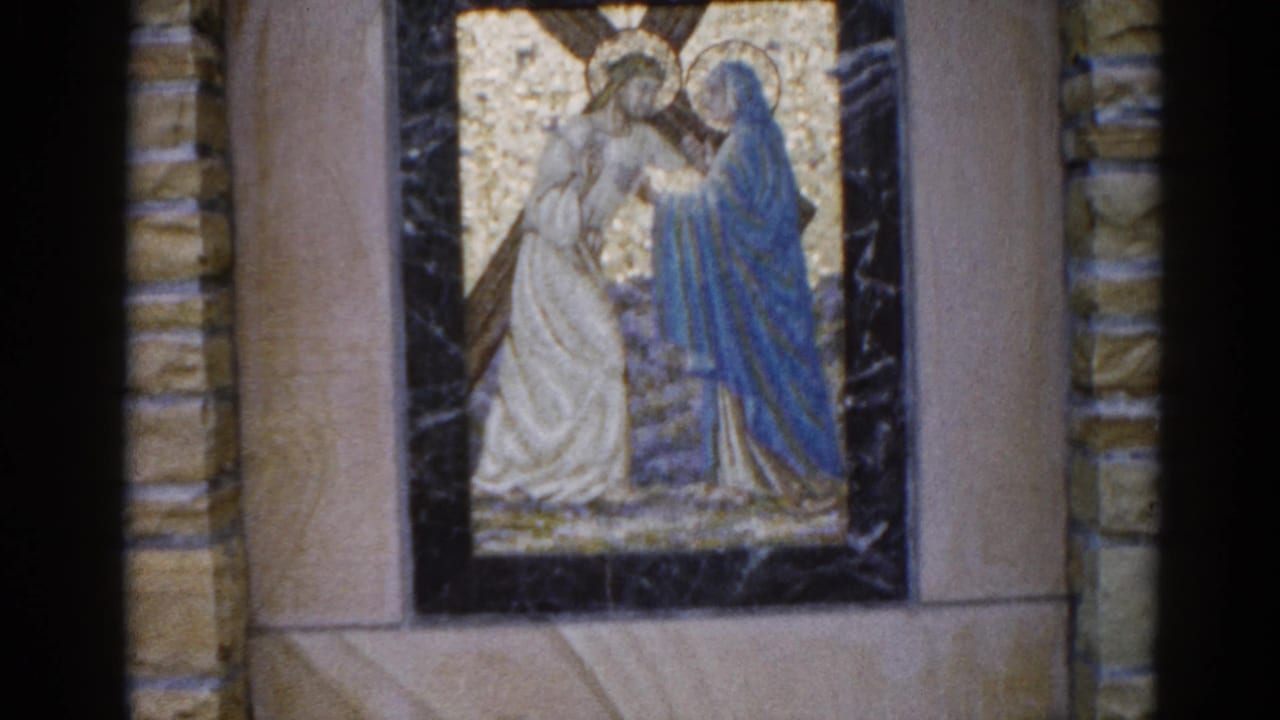 8mm footage from 1962 Illinois church: mosaic of a white-robed haloed figure and a blue-robed figure in gold tesserae, slight camera drift visible.