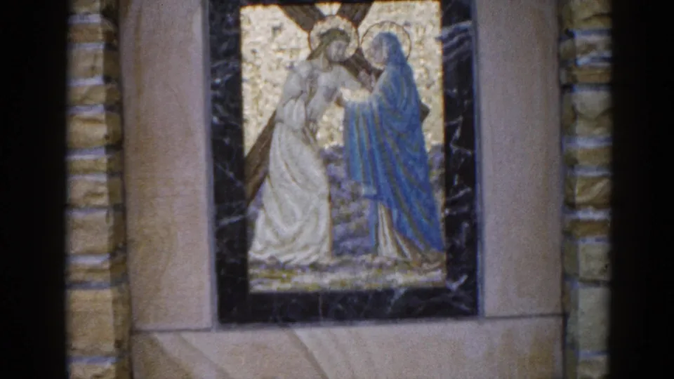 8mm footage from 1962 Illinois church: mosaic of a white-robed haloed figure and a blue-robed figure in gold tesserae, slight camera drift visible.