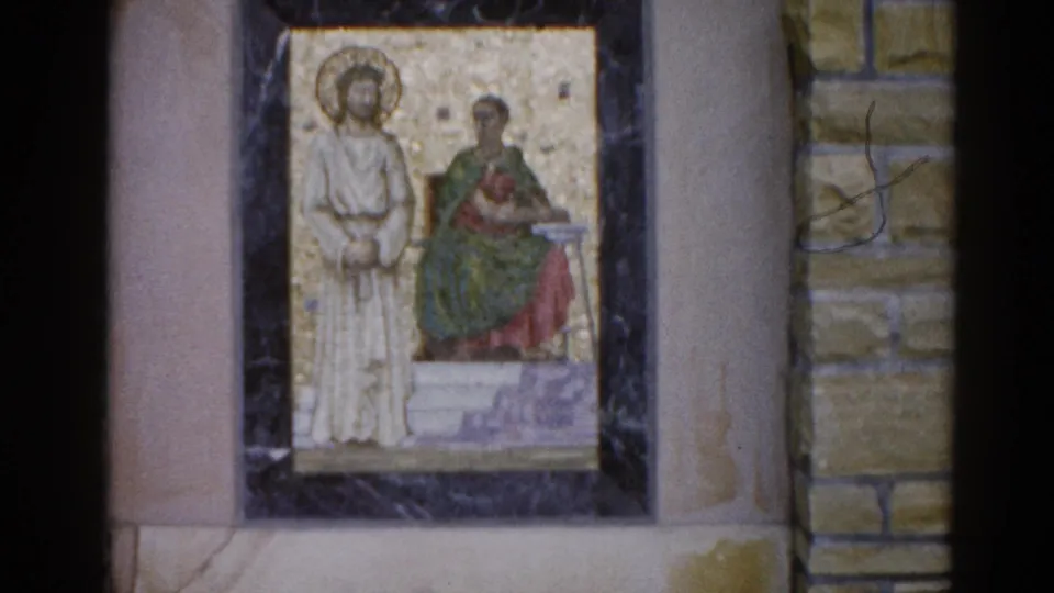 Religious mosaic icon, two haloed figures in traditional iconographic style, stone wall surround, Illinois circa 1962; film scratch visible at right edge.