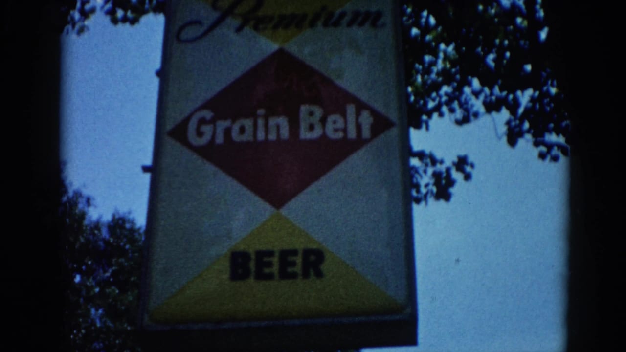 Grain Belt Beer Premium diamond sign photographed circa 1962, Illinois: red center diamond reading 'Grain Belt', yellow lower triangle, bold 'BEER' text, script 'Premium' above, blue sky behind.