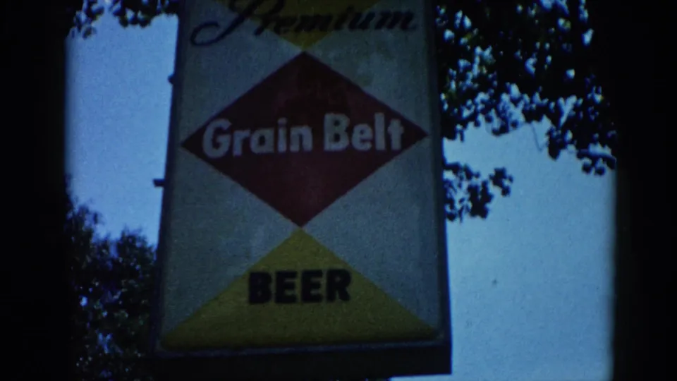 Grain Belt Beer Premium diamond sign photographed circa 1962, Illinois: red center diamond reading 'Grain Belt', yellow lower triangle, bold 'BEER' text, script 'Premium' above, blue sky behind.