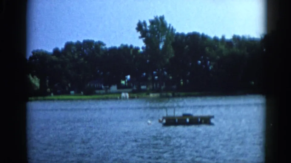 Floating wooden dock with a figure nearby on a Midwest lake, 8mm home movie, Illinois circa 1962.
