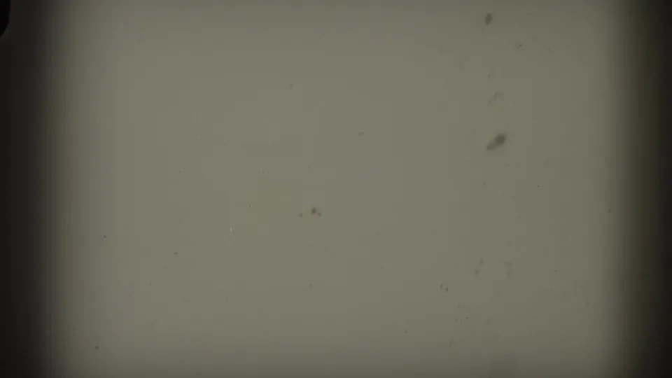 Overexposed flash frame from 8mm home-movie reel, showing almost no image detail, likely a transition or scene break.