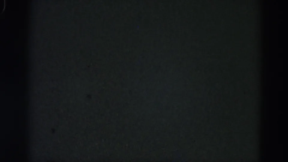 Severely underexposed or damaged 8mm film frame from a 1962 Illinois home-movie reel; no subjects visible, only dark grain.