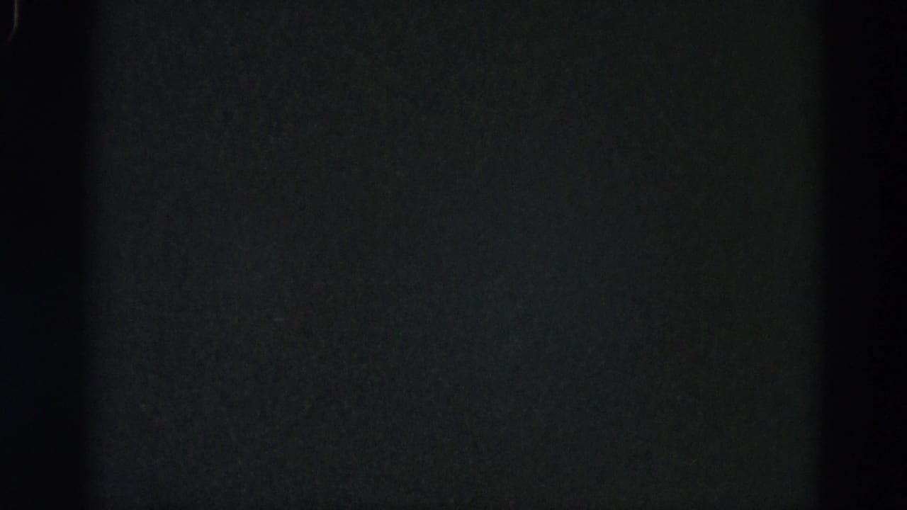 Underexposed 8mm frame from a 1962 Illinois home-movie reel showing near-black field with coarse film grain and no discernible content.
