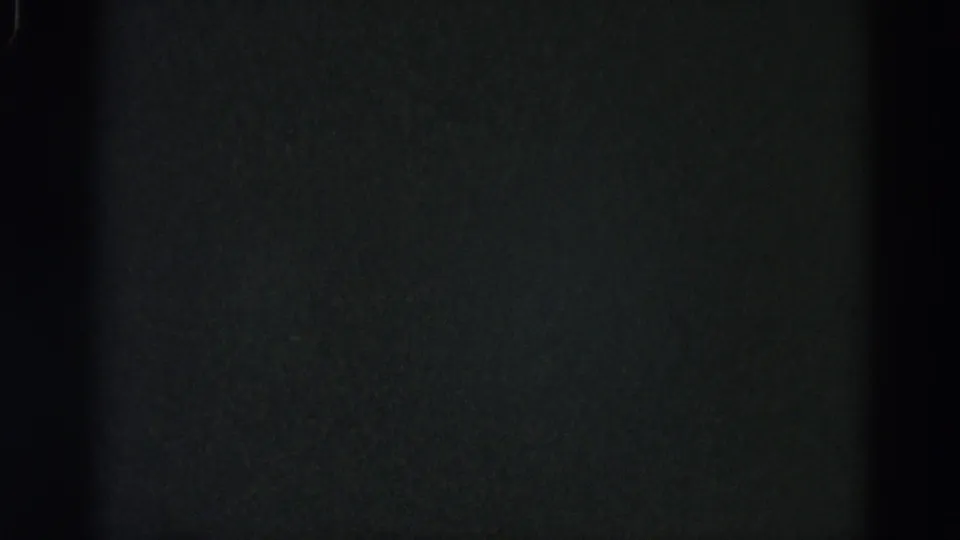 Underexposed 8mm frame from a 1962 Illinois home-movie reel showing near-black field with coarse film grain and no discernible content.