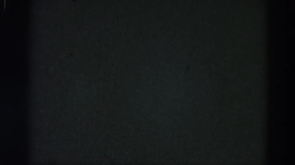 Damaged or unexposed 8mm frame from a 1962 Illinois home-movie reel; dark field with grain texture, no content recoverable.