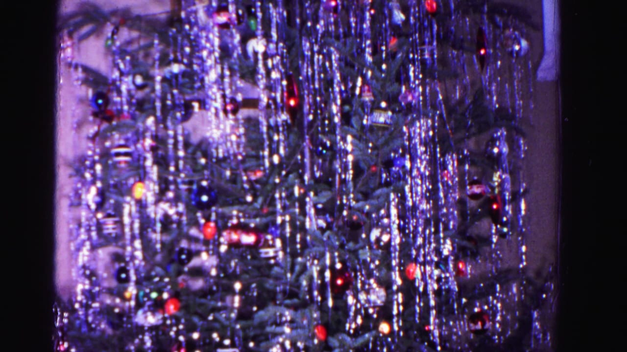 8mm home movie still of a densely tinsel-covered Christmas tree with multicolored glass ornaments, Hagerstown, Maryland, 1962.