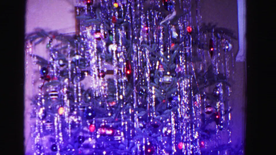8mm home movie frame of a tinsel-decorated Christmas tree with a slight pull-back revealing the interior wall, Hagerstown, Maryland, 1962.