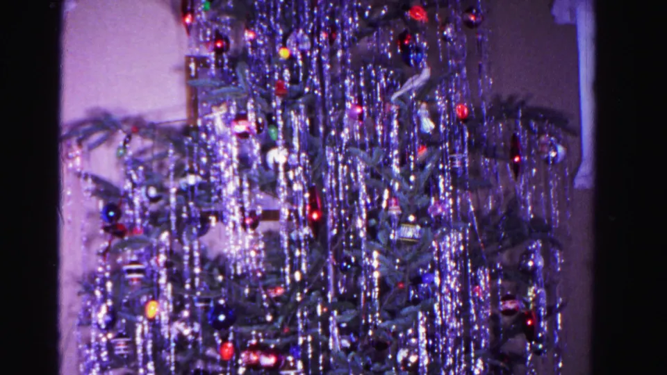 8mm color home movie frame of a tinsel-laden Christmas tree with colored ornaments and interior room context, Hagerstown, Maryland, 1962.